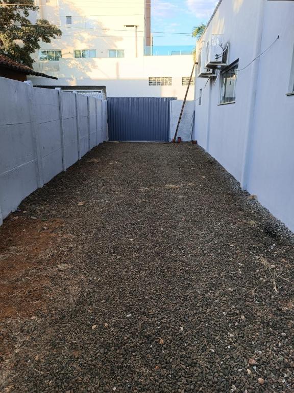 a side walk next to a white fence at Casa no centro in Mineiros