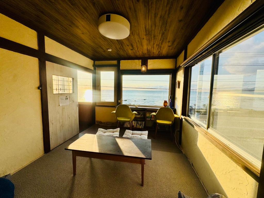 a room with a table and chairs and a large window at Bear Foot 蒼 in Yakumo