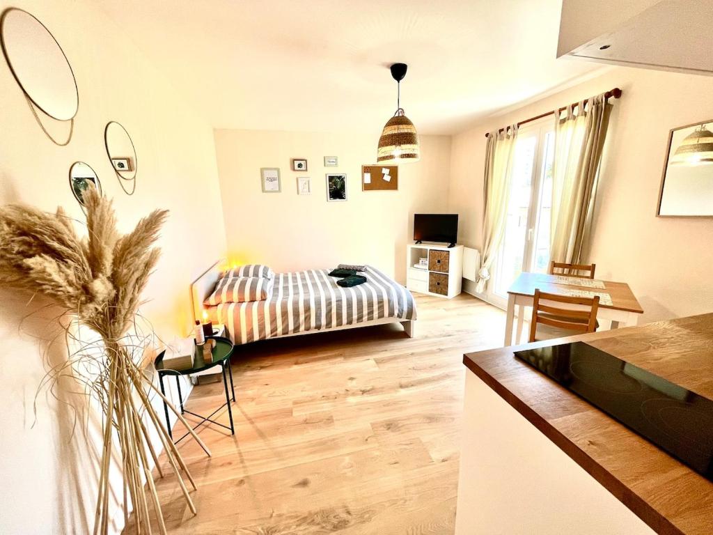 Una sala de estar con una cama y una cocina. en Cocooning appartement, en Joué-lès-Tours