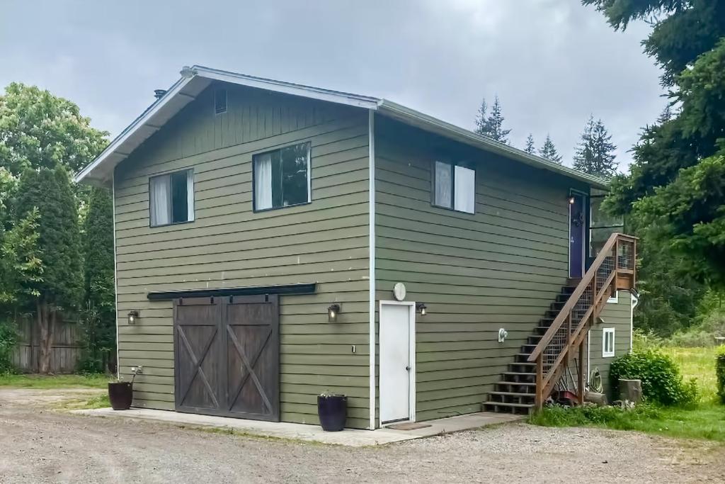 Una casa verde con garaje y escalera en Scandia Suite, en Keyport