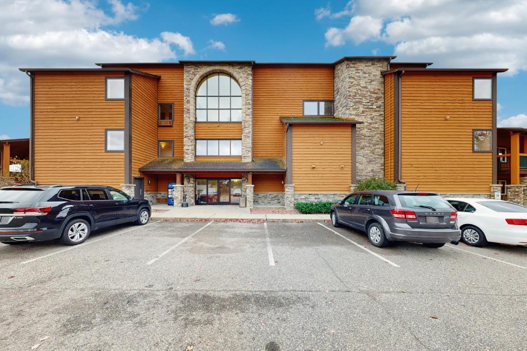 two cars parked in a parking lot in front of a building at Dells Den Condo #7306 in Wisconsin Dells