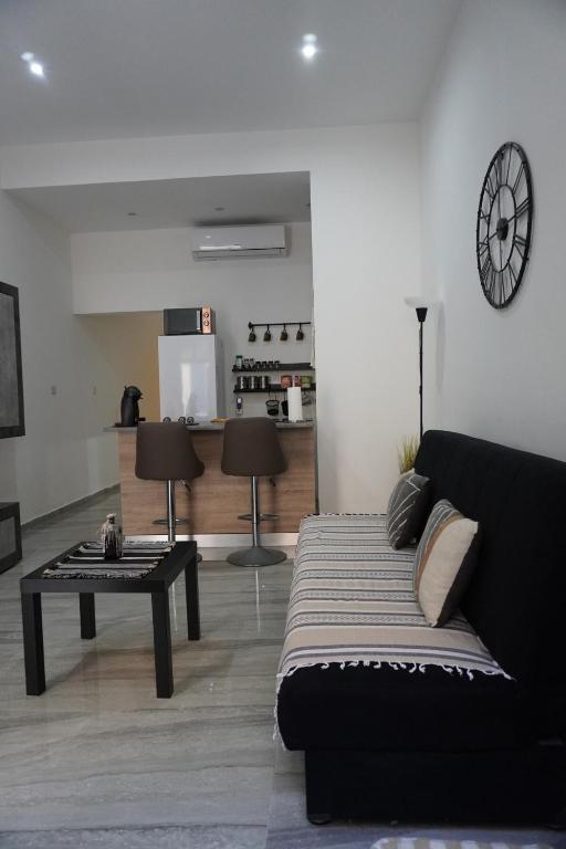 een woonkamer met een zwarte bank en een tafel bij San Nikola Getaway in Sliema