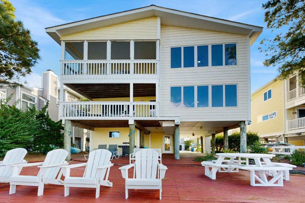 un groupe de chaises et de tables blanches devant une maison dans l'établissement South Bethany --- 309 W 2nd St, à South Bethany