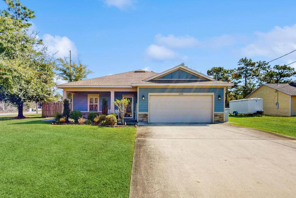 a house with a white garage in a yard at Blue Pearl in Navarre