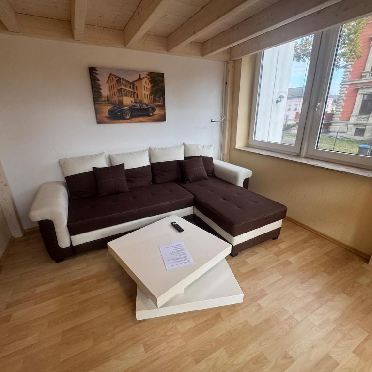 a living room with a couch and a coffee table at Apartment Wintergarten in Reichenbach im Vogtland