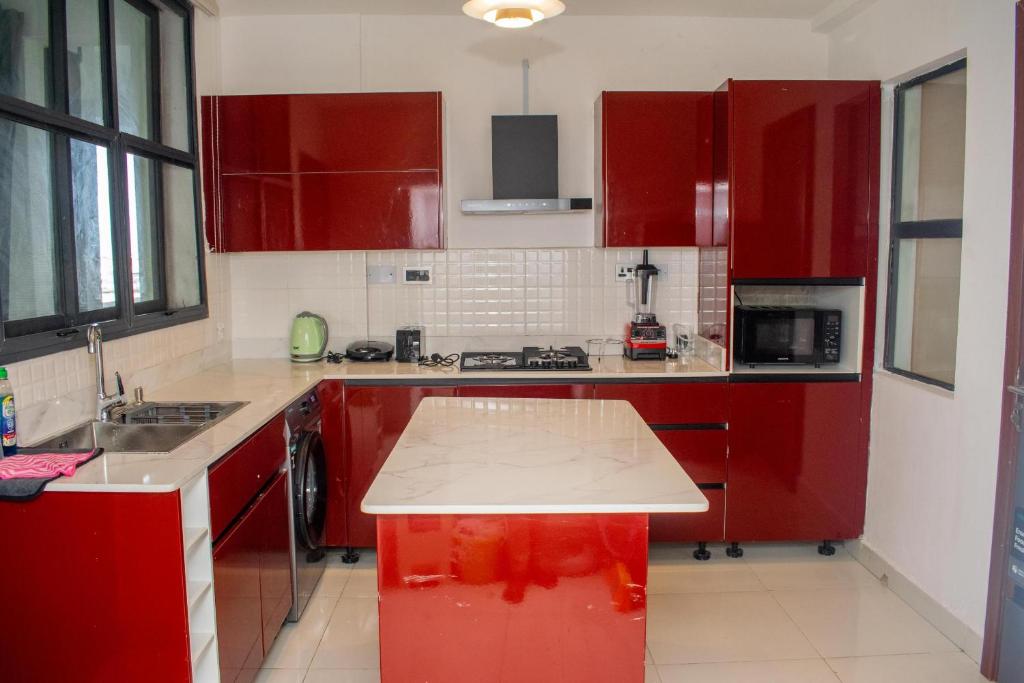 a kitchen with red cabinets and a counter top at PWJ Apartments in Lagos