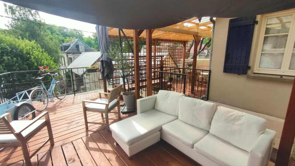 ein Wohnzimmer mit einem Sofa und Stühlen auf einer Terrasse in der Unterkunft Studio Amboise, parking, terrasse et jardin in Amboise