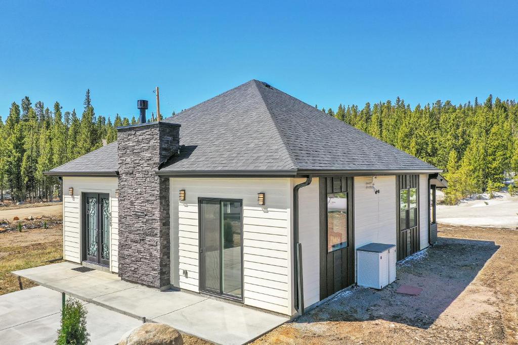 a small white house with a gray roof at Romantic Mountain Retreat with Scenic Views! in Idaho Springs