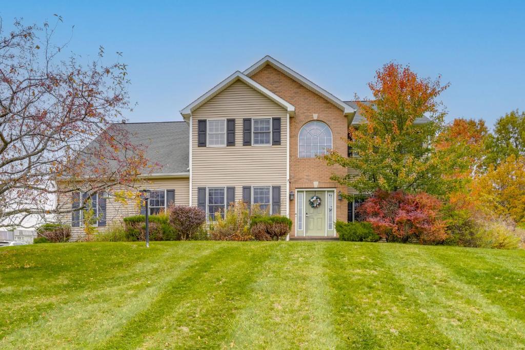 a large house with a large grass yard at Expansive Upstate Home with Home Theater! in East Schodack