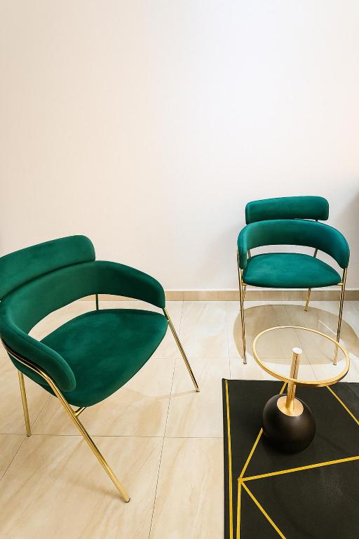two green chairs and a table in a room at Résidence Luxe Dakar Centre Ville in Dakar