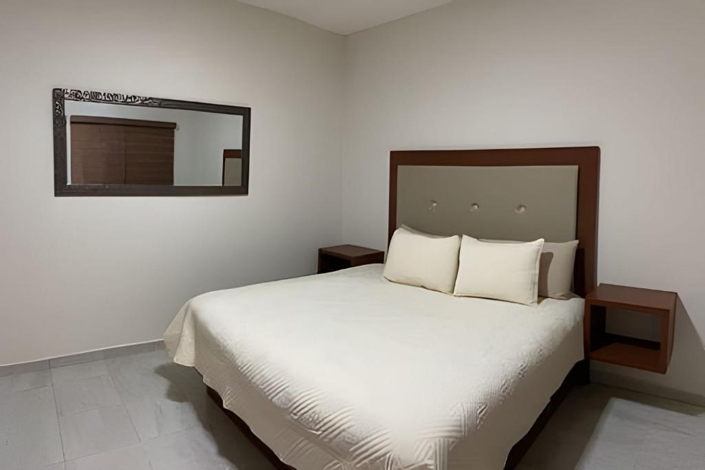a bedroom with a bed with a mirror on the wall at Casa El Dorado - a 2 minutos de la Playa Miramar in Colonia Miramar