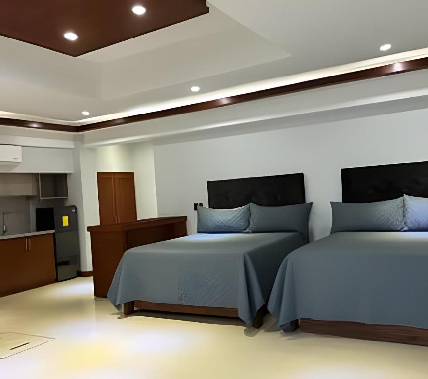 a bedroom with two beds and a kitchen at Loft El Tular - a 5 minutos de la Playa in Colonia Miramar