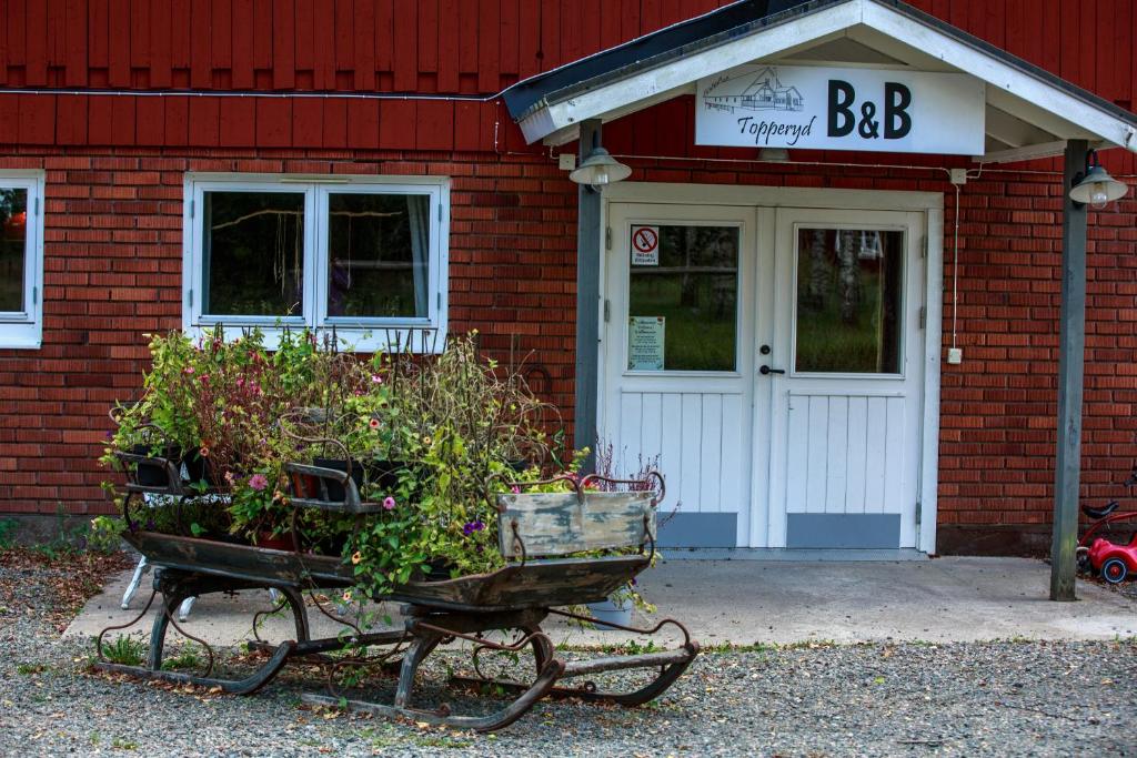 a building with two baskets of plants in front of it at Topperyd Bed & Breakfast in Nässjö