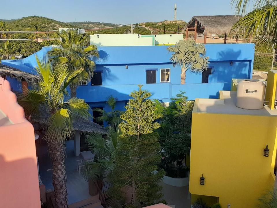 a blue building with palm trees in front of it at Posada Nomad in San José del Cabo