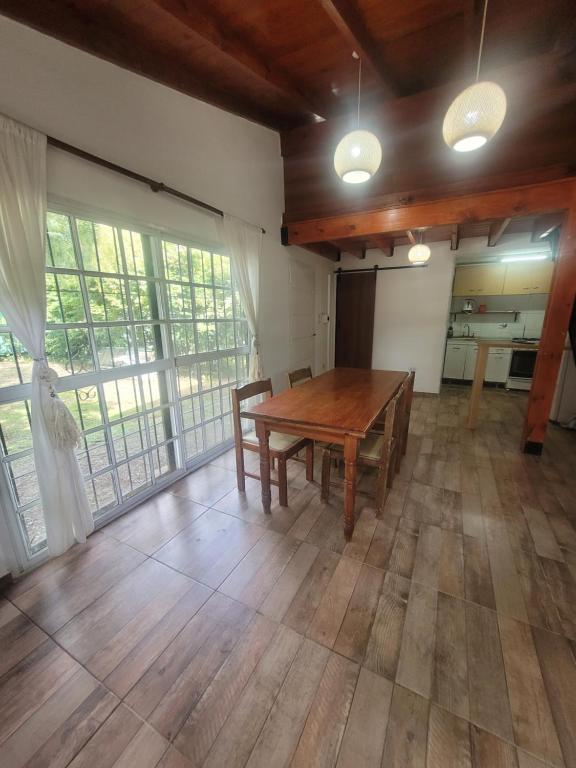 a large room with a wooden table and some windows at Quinta El Reencuentro tu refugio en Campana in Campana