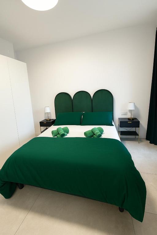 a green bed with two green pillows on it at Marisabella Suite Spa 4 in Bari