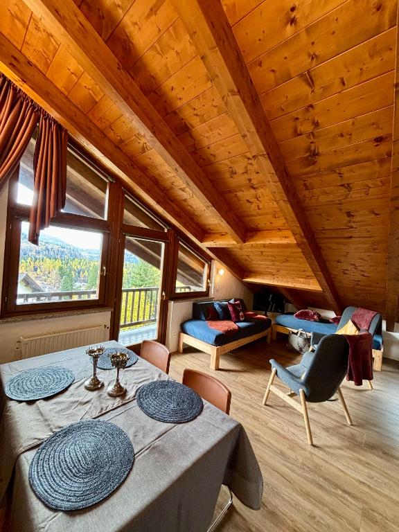 a room with a table and chairs and a room with a room at Sky Lodge Bellamonte in Bellamonte