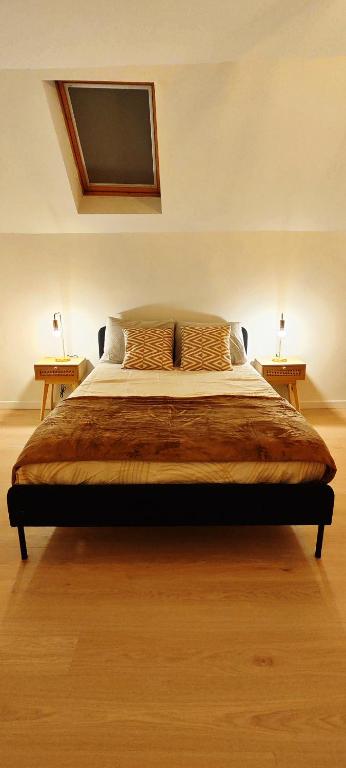 Bett in einem Zimmer mit 2 Tischen und einem TV in der Unterkunft Charmante maison à Denain en couple ou solo in Denain