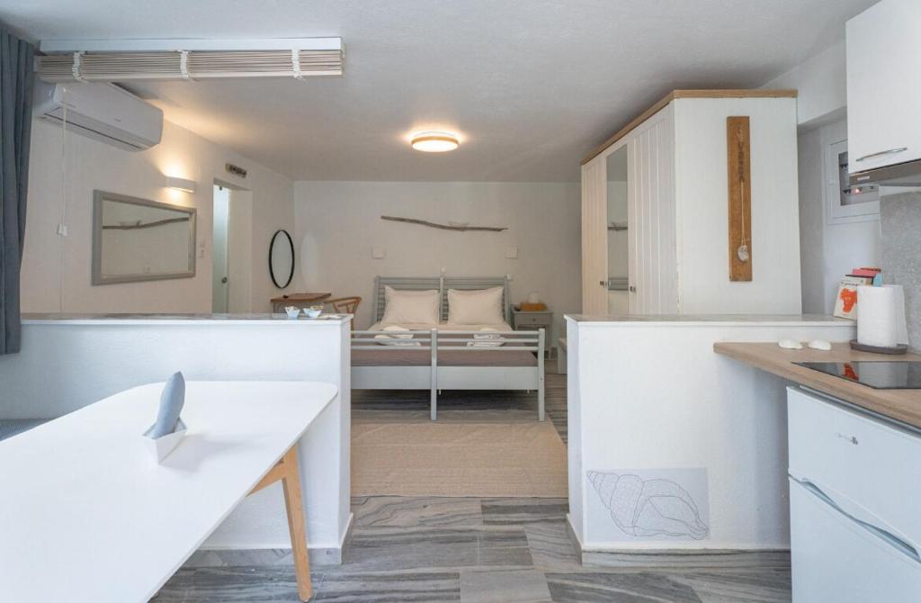 a kitchen and living room with a bed in the background at WHITE W4 new studio in Naousa in Naousa