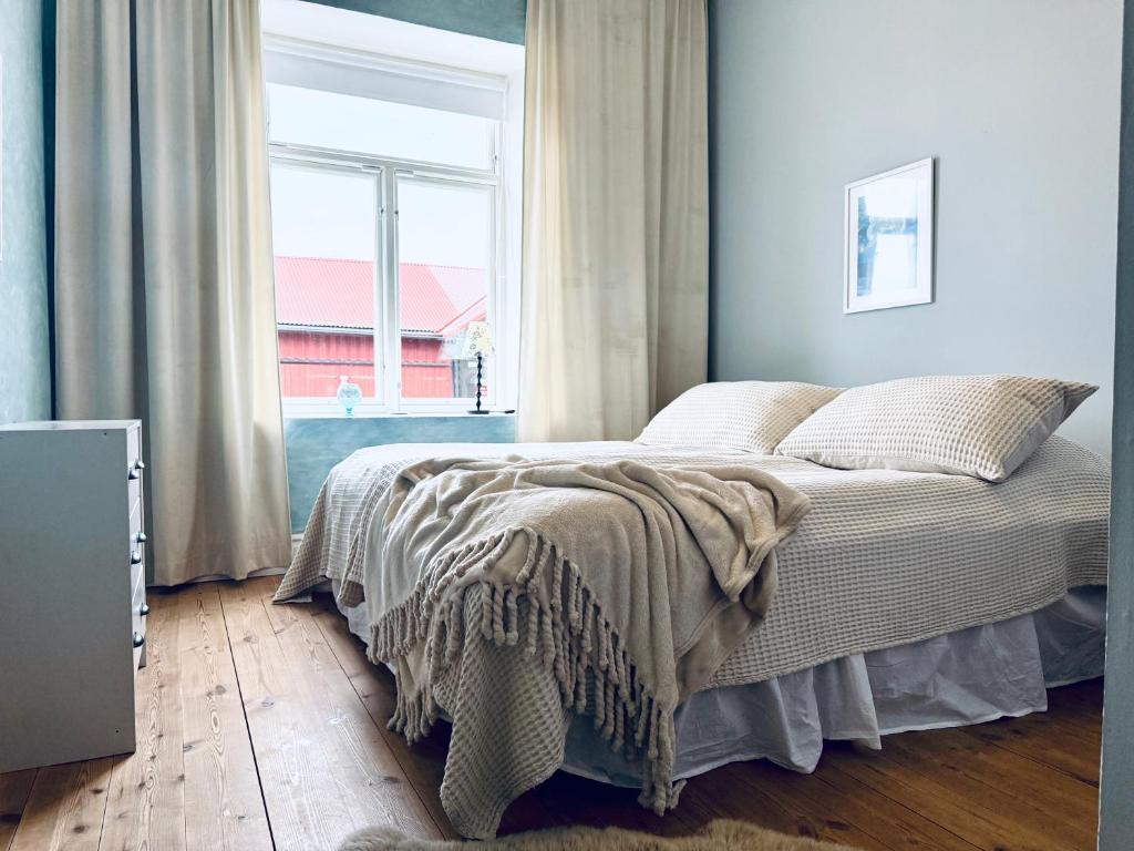 a bed in a room with a large window at Udden Retreat-Bed & Breakfast in Skinnskatteberg