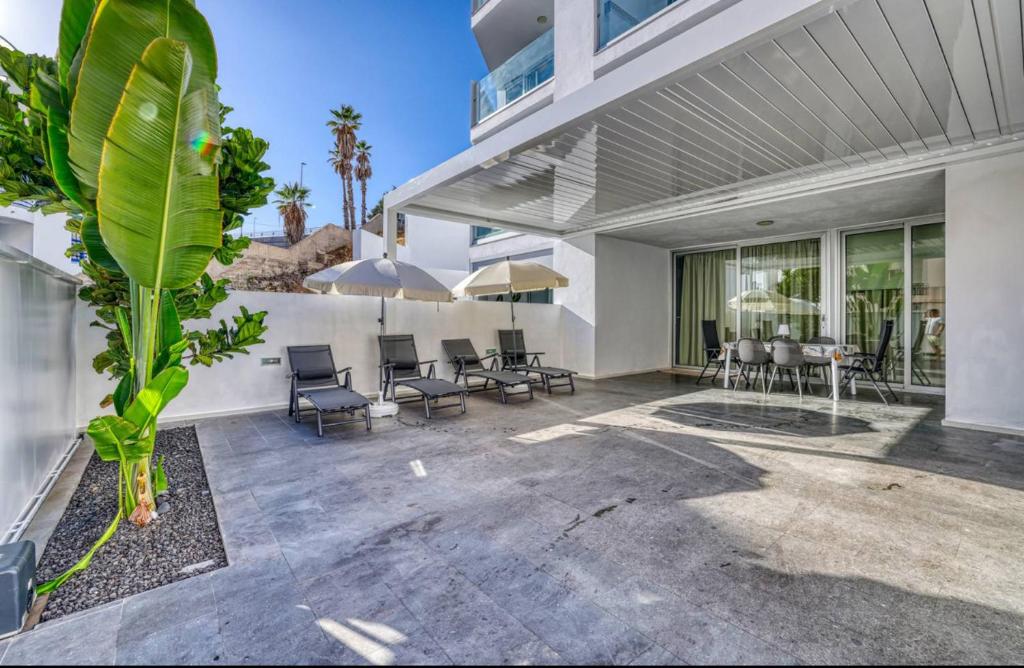 una casa con un patio con sillas y una mesa en MSV Beach, en Puerto Naos