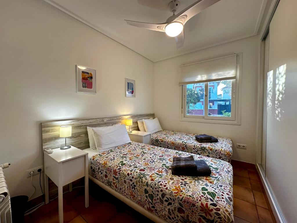 a small bedroom with two beds and a window at Villa Alegre - 2 bed villa with private heated pool on Mar Menor Golf - family friendly in Torre-Pacheco