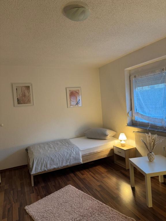 een kleine slaapkamer met een bed en een raam bij FeWo Im Drosselnest in Hechingen