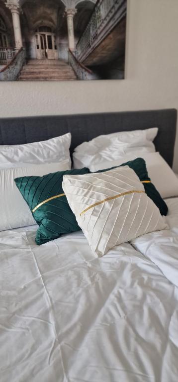 a white bed with pillows on top of it at Cozy & Fully Equipped Flat in a Prime Location in Essen