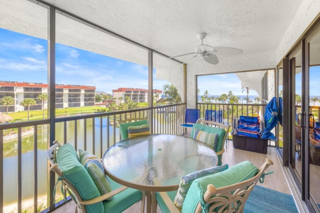 萨尼贝尔Pointe Santo B32 condo的阳台配有玻璃桌和椅子