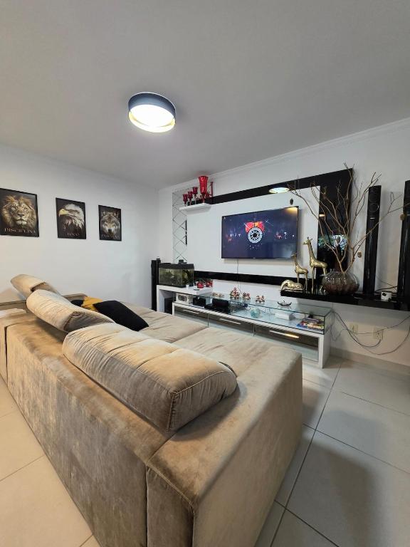 a living room with a large couch and a flat screen tv at Apartamento Artzoo in Pomerode