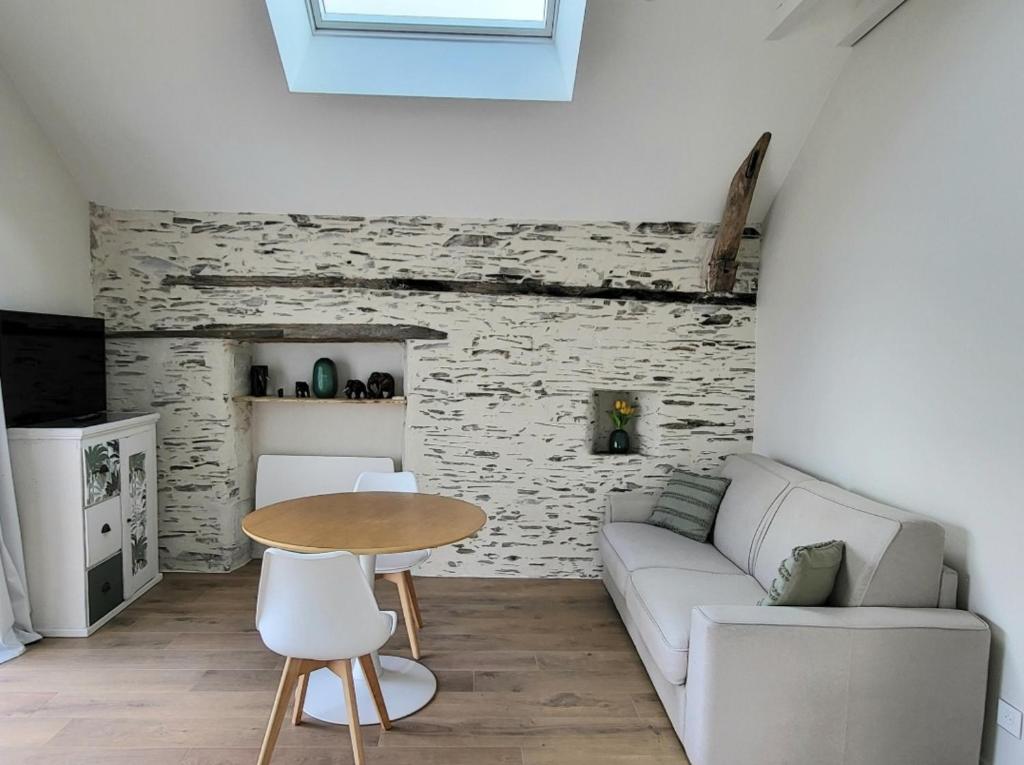a living room with a couch and a table at Le Gemmois in Sainte-Gemme-sur-Loire