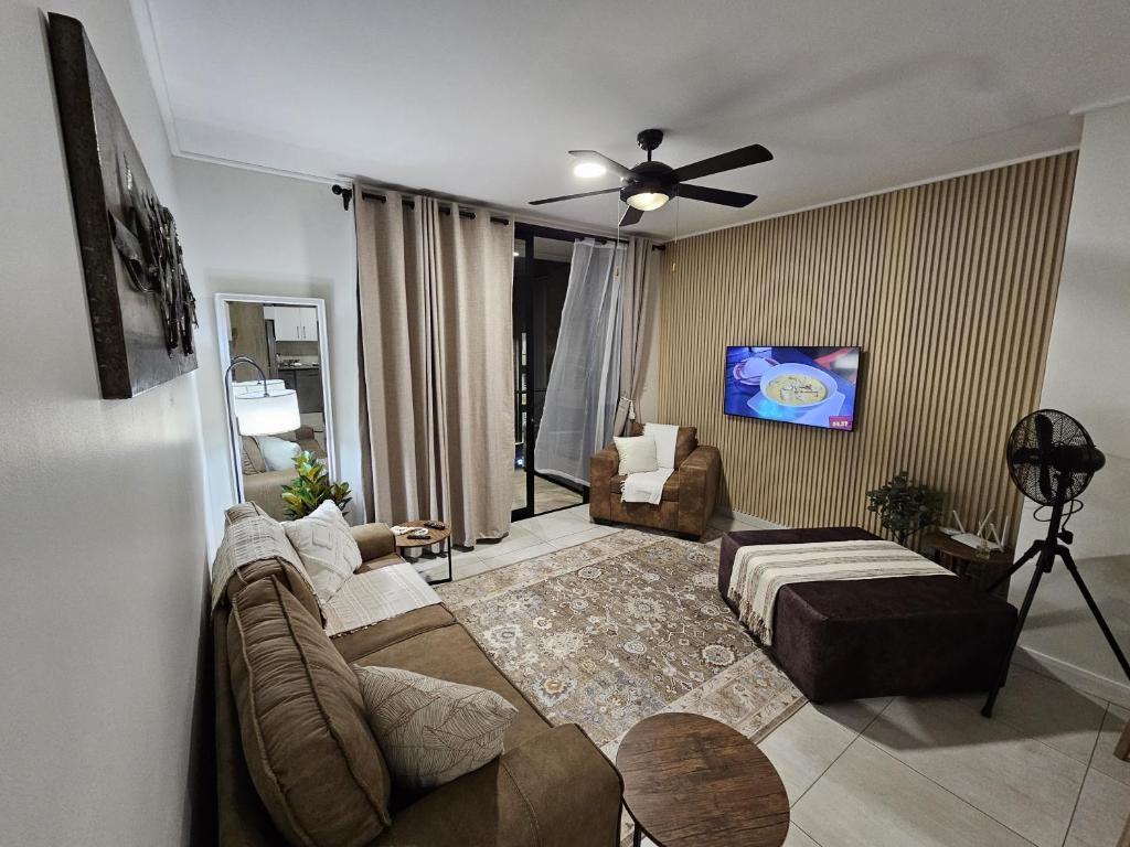 a living room with a couch and a tv at CostaBella in Gqeberha