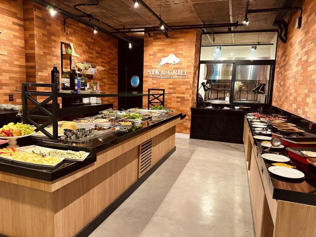 bufet z talerzami w restauracji w obiekcie Suíte Particular no Transamerica Executive Faria Lima w São Paulo