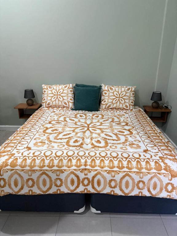 a bed with a blanket and pillows on it at Carolus Suites in Gros Islet