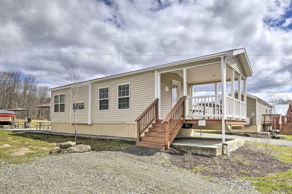 ein kleines Haus mit einer Veranda und einer Treppe darauf in der Unterkunft Hidden Gem Cottages & Cozy Suites at Equestrian House PA in Pleasant Mount