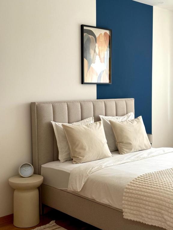 a bedroom with a bed with a blue wall at Stan na dan Bogdan Ub in Ub