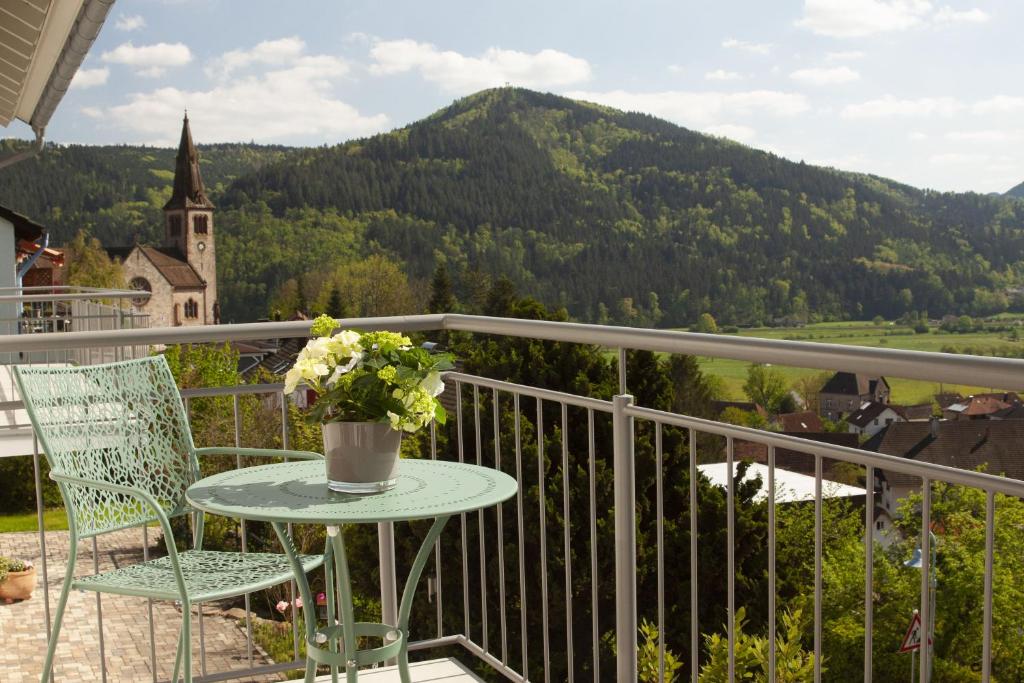 a table and chairs on a balcony with a mountain at Sonnenterrasse 9 in Fischerbach