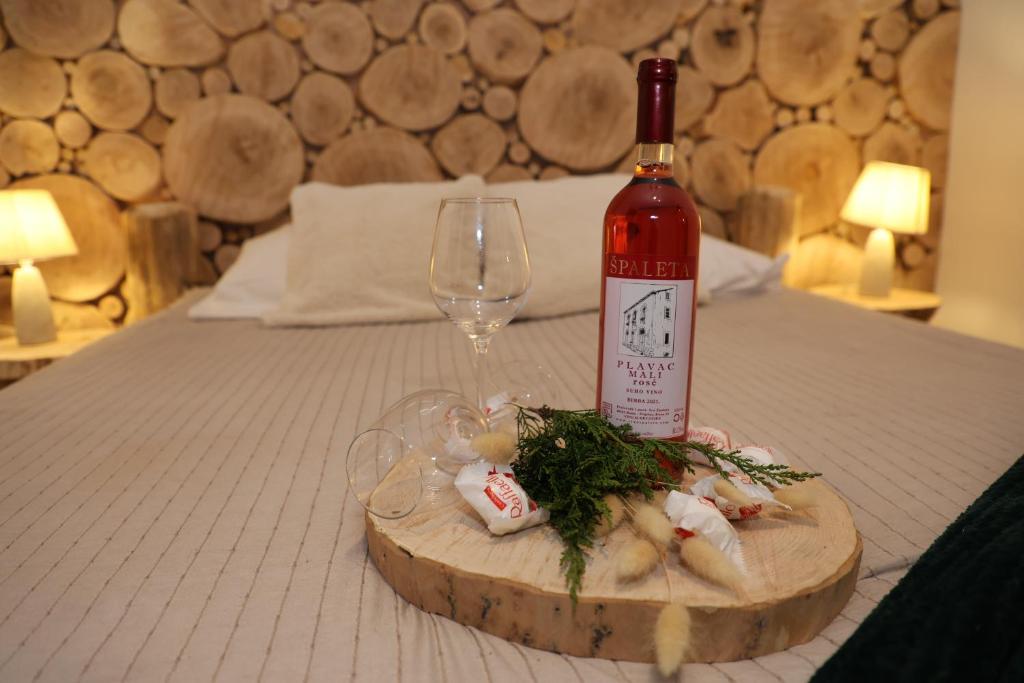 a bottle of wine and a wine glass on a bed at Domek Rochowa Buźnica apartament 2 in Zakopane
