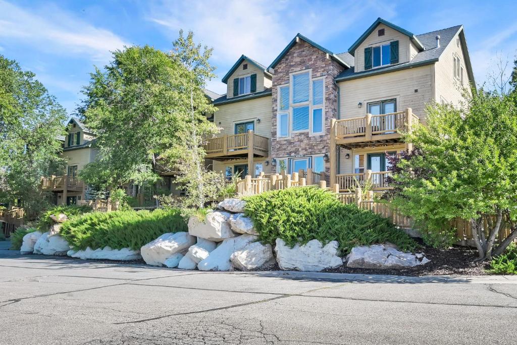 a large house with rocks in front of it at Eden Mountain Condo with Views Pool & Hot Tub Access in Wolf Creek Village