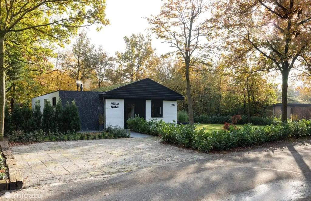 una casa con techo negro y entrada para autos en Villa Nami, en Denekamp