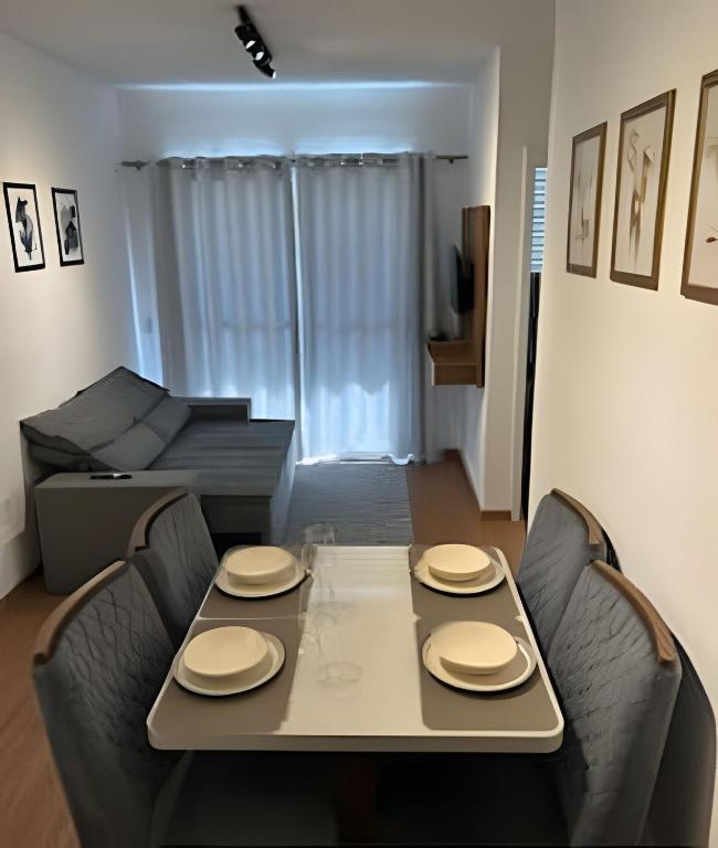a dining table and chairs in a living room at Mel Prime Loft – executive apartment in Extrema, MG in Extrema