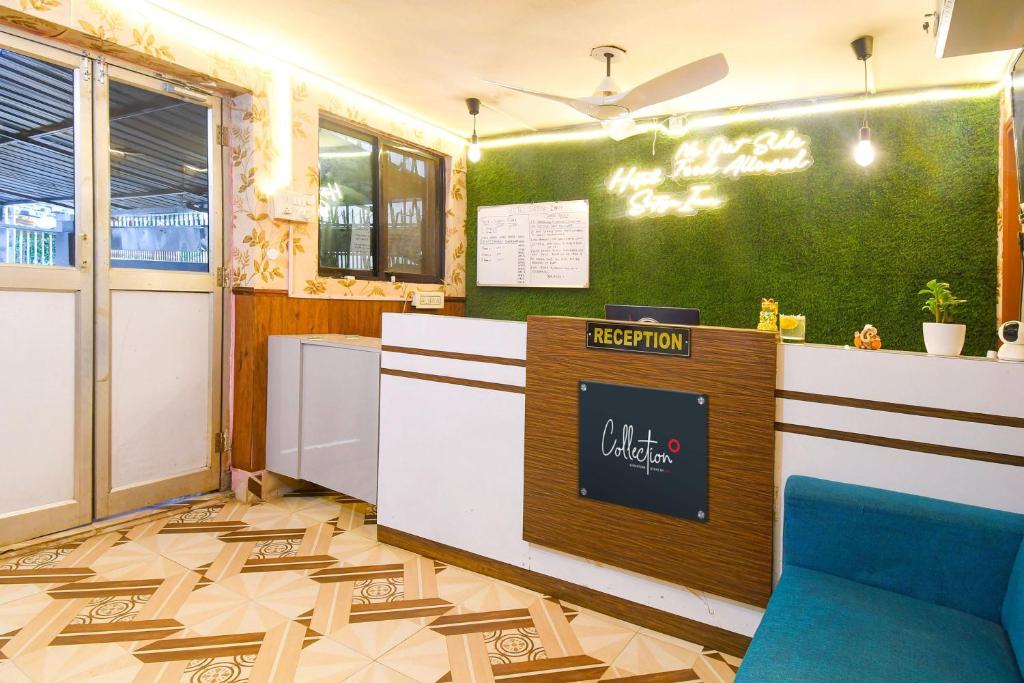 KhandagiriHotel O Sawan INN的一间设有前台和绿色墙壁的餐厅