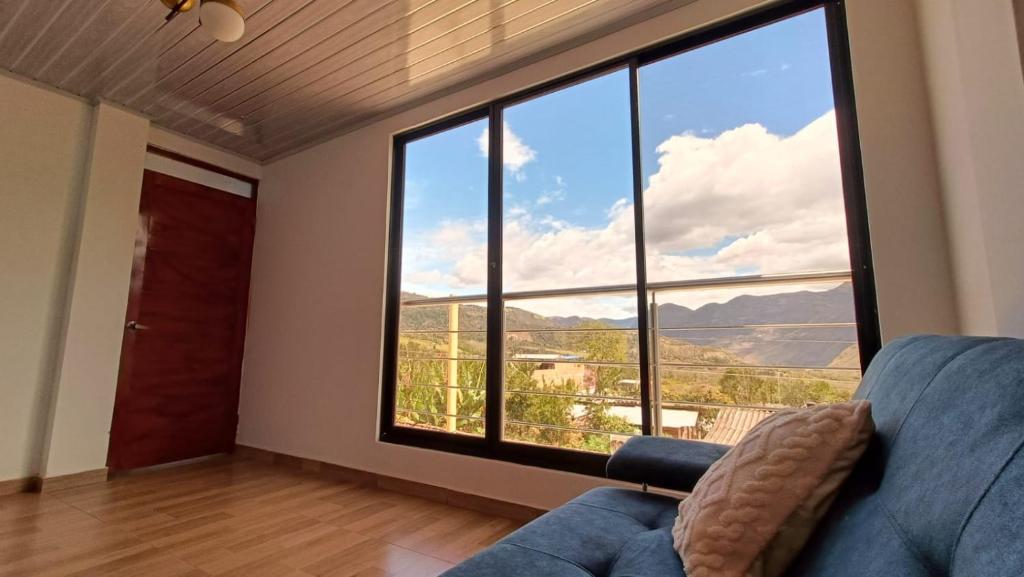 a living room with a couch and a large window at Amaru 