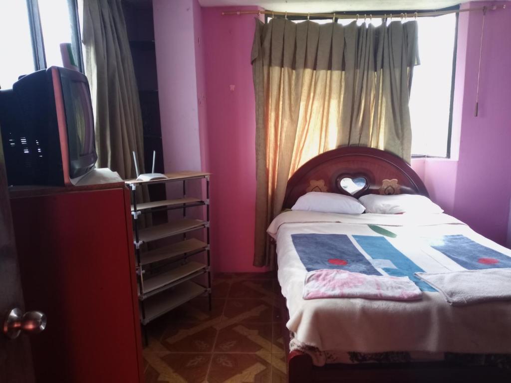 - une petite chambre avec un lit et une télévision dans l'établissement Ortega'S Guest House, 