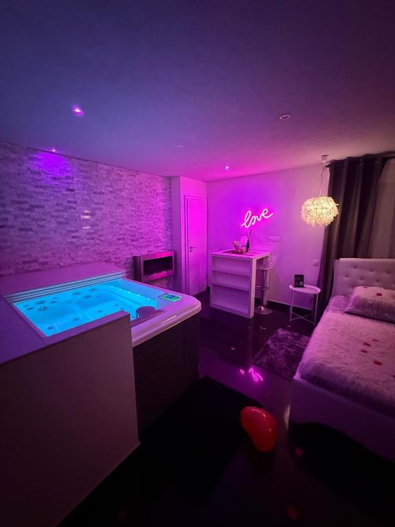 une chambre violette avec un jacuzzi et un lit dans l'établissement Cocon douceur, à Gingsheim