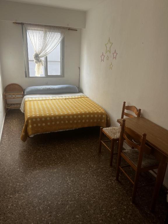 a bedroom with a bed and a bench and a window at habitacion en silla in Silla