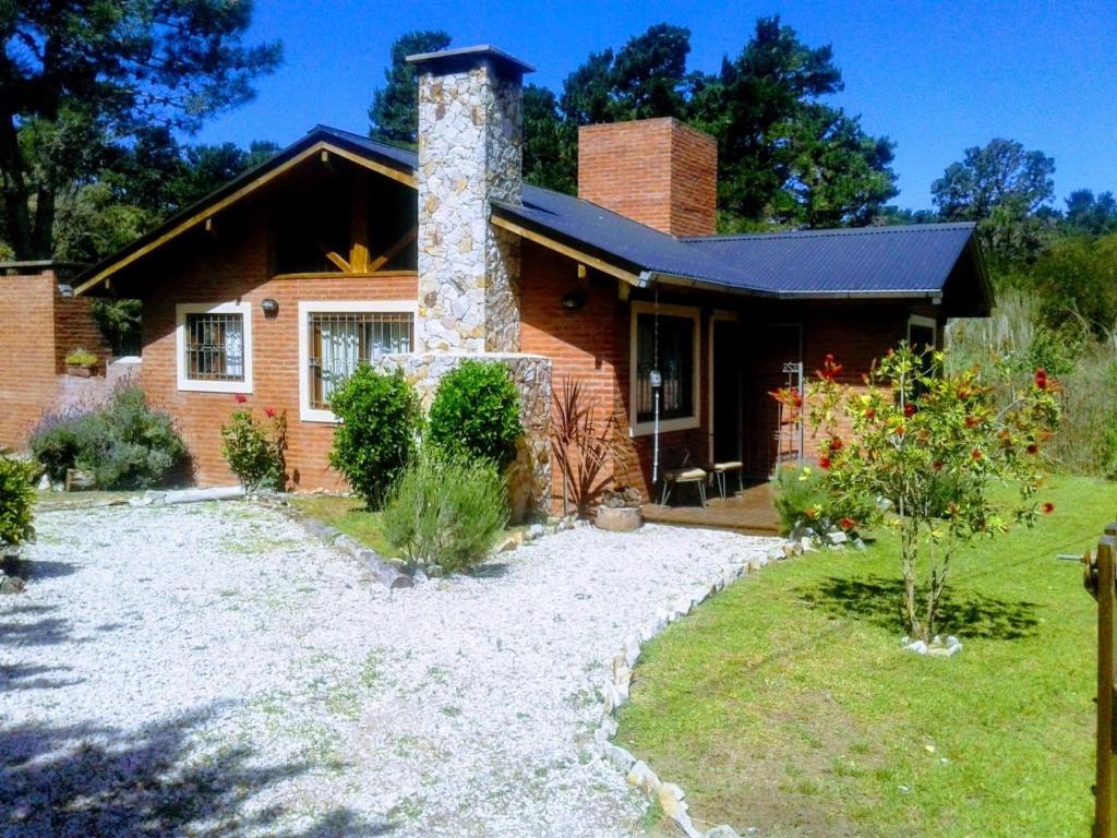 ein Backsteinhaus mit Schornstein und Hof in der Unterkunft Alma del Bosque PILETA E HIDROMASAJES Semiclimatizados in Mar Azul