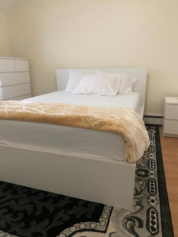 a bed with white sheets and pillows on it at private room in Paterson
