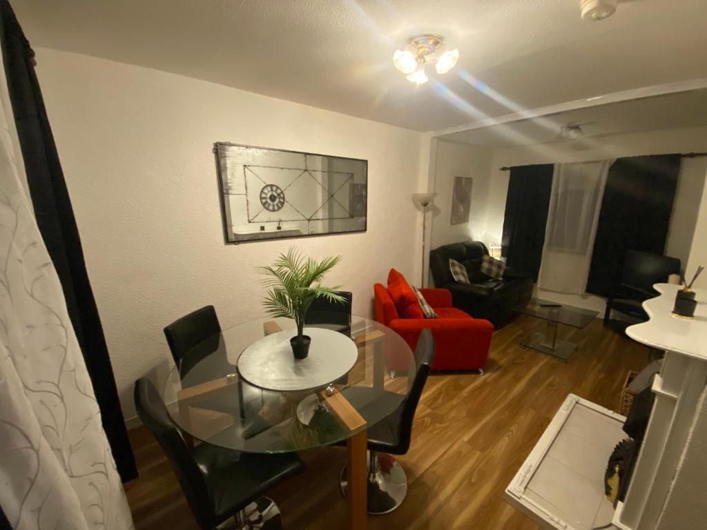 ein Wohnzimmer mit einem Glastisch und einem roten Stuhl in der Unterkunft meadow house close to city center in Belfast