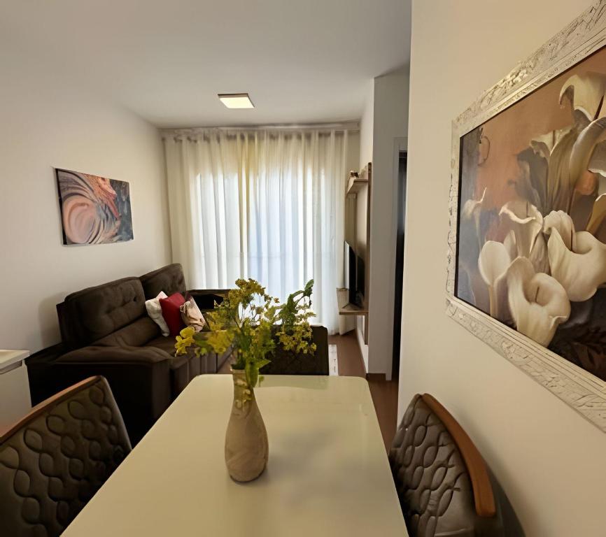a living room with a table with a vase of flowers on it at Plano 22 Prime Loft – Executive apartment in Extrema, MG in Extrema